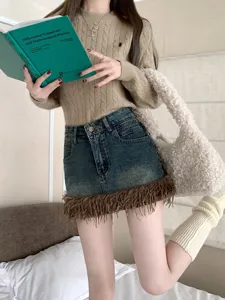Elegante minifalda vaquera de mujer con dobladillo de flecos combinada con jersey de punto.
