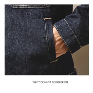 Detaillierte Nahaufnahme von Tasche und Manschette der dunklen Jeansjacke mit Kontrastnähten.