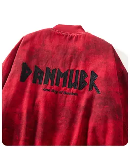 Primo piano dettaglio del retro della giacca streetwear rossa con ricamo nero.