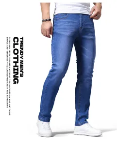 Primo piano dettagliato di jeans slim blu da uomo abbinati a sneakers bianche in studio.