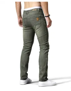 Vista posteriore dettagliata di jeans slim verdi da uomo con etichette in pelle.