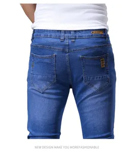 Vista posteriore dettagliata di jeans slim fit blu da uomo con tasche classiche e toppa in pelle.