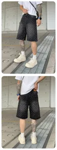Men's washed black denim shorts with all-over cross pattern, loose fit streetwear style.