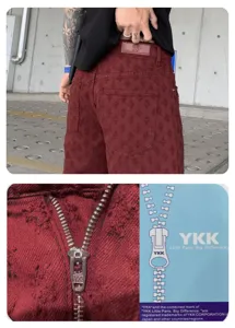 Detailed view of men's distressed burgundy denim shorts showing back pocket and zipper.