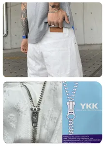 Men white distressed streetwear denim shorts with cross pattern and metal zipper details.
