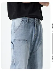 Men's casual loose denim pants detail, light blue vintage paneled streetwear trousers.