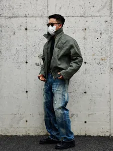 Detailed shot of men's vintage distressed loose straight-leg denim jeans streetwear.