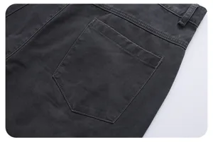 Detailed close-up of dark grey washed denim cargo pants back pocket with neat stitching.