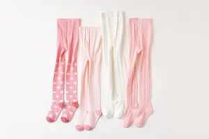 Dettaglio di collant in cotone per bambini, con motivi a cuori e trama lavorata.