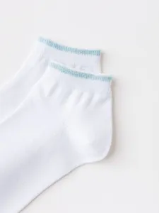 White cotton ankle socks detail showing blue glitter trim and soft knit texture close up.