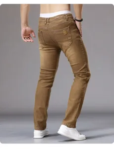 Detailed view of men's slim fit casual denim pants in classic khaki color, back pocket design.