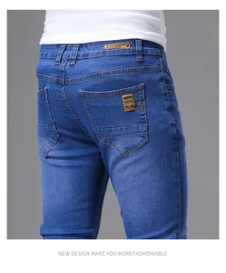 Details of men's slim fit blue denim jeans showing back pocket design and quality fabric.