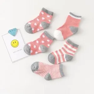 Detail view of baby cotton socks featuring cute stripe and heart patterns in pink grey.