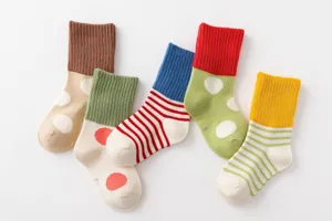 Detailed view of colorful cotton kids socks with cute polka dot and striped patterns for autumn.