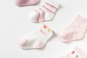 Gedetailleerde opname van ademende babysokken met schattige strepen en hartjespatronen voor lente.