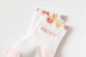 Close-up detail van ademende katoenen babysokken met kleurrijke hartjes en happy patroon.