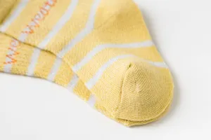 Gros plan détaillé de chaussettes rayées en coton pour enfants, maille fine et douce.
