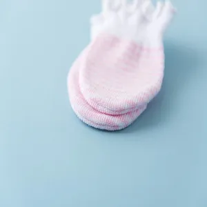 Close-up detail of pink and white striped baby anti-scratch mittens with soft cotton fabric.