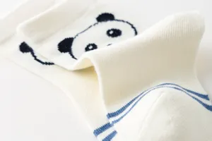 Detalle en primer plano de calcetines de algodón gruesos y cálidos infantiles con oso panda.