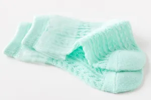 Detailopname van mintgroene ademende babynnetsokken met kant, lichtgewicht voor de zomer.