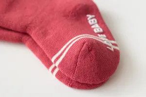 Close-up detail of winter thick fleece-lined baby thermal socks with anti-slip text grip.