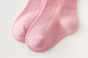 Close-up detail shot of pink knit children socks featuring soft texture and breathable ribbed cuff.