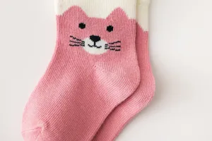 Primo piano calzini neonato lavorati a maglia gatto rosa morbido materiale cotone trama.