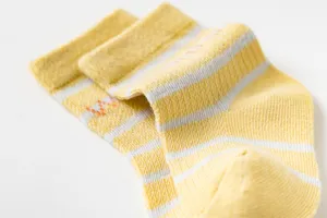 Gros plan de chaussettes pour bébé en coton rayé jaune et blanc, style mesh respirant.