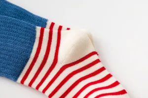 Close up of cozy cotton striped socks for kids, featuring blue and red knit design.