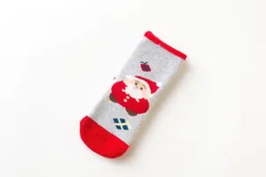 Primo piano dettagliato delle calze da neonato natalizie spesse con motivo di Babbo Natale e tacco rosso.
