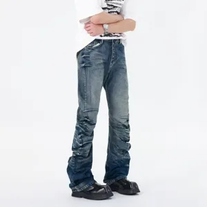 Detailed view of men's blue stacked flared jeans with stylish pleated texture and button fly.