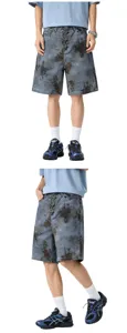 Detailed view of loose blue camouflage denim shorts with unique metal clasp closures.