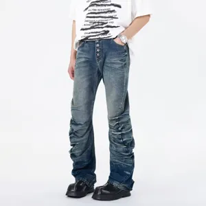 Men's streetwear stacked pleated flared jeans, blue distressed denim trousers with button fly.