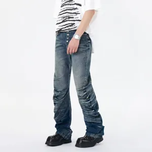 Detail view of men's blue stacked flare denim jeans featuring unique wave pleats and button fly.