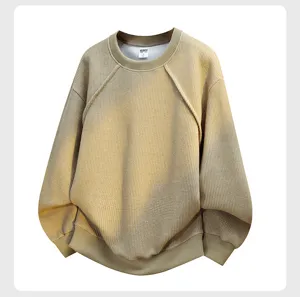 Detail view of the khaki waffle knit crewneck sweatshirt, showing texture and collar tag.