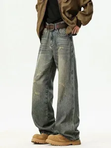 Detail view of vintage distressed loose straight-leg denim jeans showcasing abrasion and worn texture.
