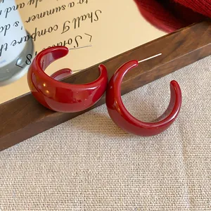 Glänzende dunkelrote Creolen für Damen, schickes minimalistisches Design, elegantes Accessoire.