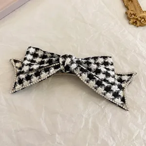 Elegante schwarz-weiße Hahnentritt-Schleifen-Haarspange mit glitzernden Strasssteinen.