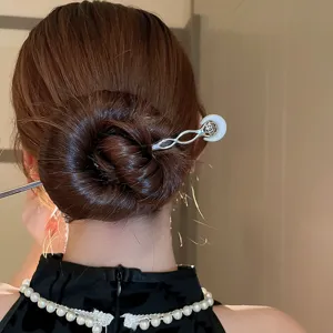 Close up detail of Chinese style metal hair stick with white moon decor for bun hair styling.