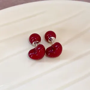 Detail shot of ankora red double ball stud earrings, glossy minimalist fashion jewelry for women.
