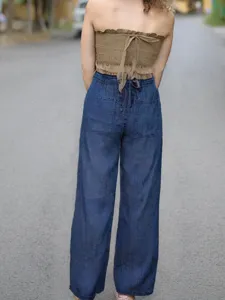 Detail view of back strap denim wide-leg pants and smocked bandeau top in soft summer style.