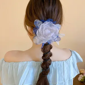 Detailopname van blauwe mesh bloem haarrekkertje met spiraaldesign, elegant haaraccessoire detail.