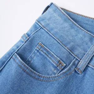 Primo piano dettagliato di pantaloni in denim azzurro con cuciture marroni a contrasto.