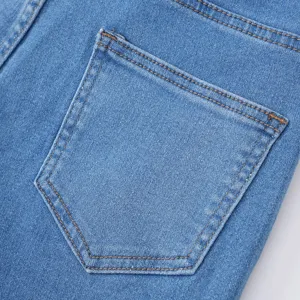 Dettaglio tasca posteriore di jeans in denim, classico tessuto in cotone elastico blu.
