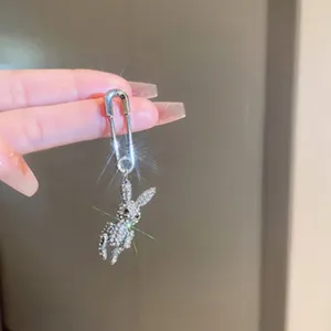 Detailed shot of a sparkling rhinestone rabbit pendant safety pin earring, fashion jewelry.