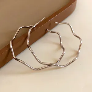 Irregular wavy silver hoop earrings featuring a chic metallic design for daily fashion wear.