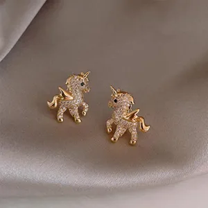 Close-up of sparkling crystal unicorn stud earrings with gold finish, elegant jewelry detail.