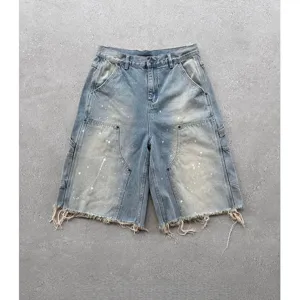 Short en denim délavé bleu clair homme, style streetwear, éclaboussures de peinture et franges.