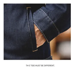 Nahaufnahme der dunklen Jeans-Arbeitsjacke mit Tasche und kontrastierenden Nähten.