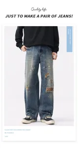Detailed view of heavy washed vintage blue wide leg ripped jeans with paint splatter.